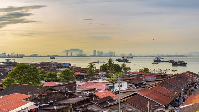Morning view of cityscape and boat traffic in a harbor with amazing cloud moving as background on the mountain range in Butterworth, clan jetties Georgetown, the capital of Pulau Penang, Malaysia.