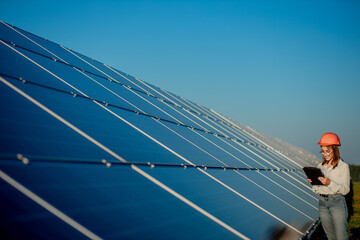 Inspector Engineer Woman Holding Digital Tablet Working in Solar Panels Power Farm, Photovoltaic...