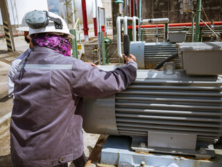 Technician checking and reading data vibration measurement of motor in power plant.