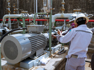 Technician checking and reading data vibration measurement of motor in power plant.