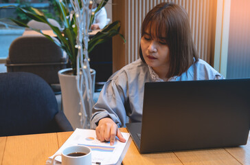 Asian women are working on financial costs in a coffee shop.