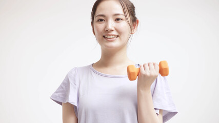 ダンベルで筋トレをする若い女性