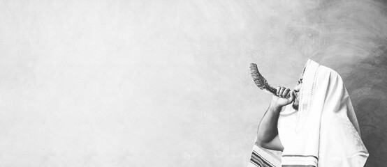 Happy Yom Kippur.Happy new year.Jewish man in Tallit blowing the Shofar (horn) of Rosh Hashanah...