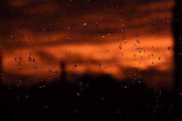 Sunset through the window. Raindrops dripping from the window
