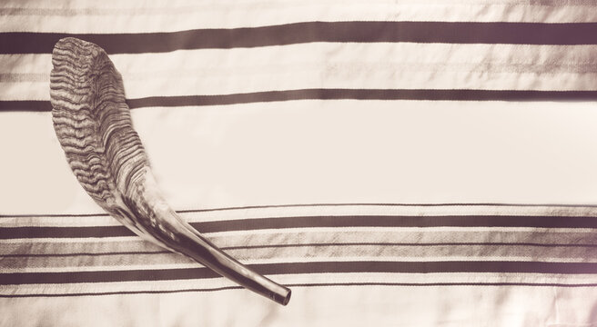 Top view of shofar (horn) on talit for prayer with talit.Prayer Shawl - Tallit and Shofar (horn) jewish religious symbol.Faith Tradition and Religion concept.Major holidays.Jewish Holidays Background.