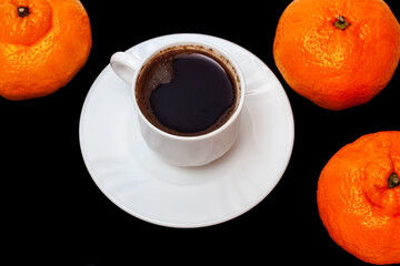 White cup of espresso coffee and orange tangerines isolated on black. Cafe concept. Chinese new year 2021
