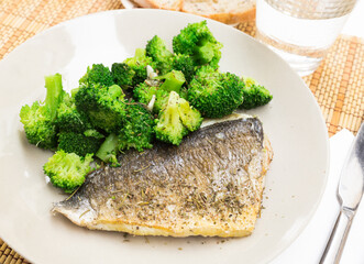 dish of fried dorado fish fillet with boiled broccoli