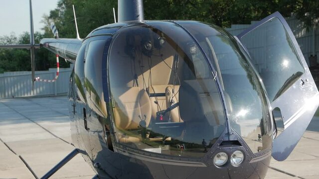 Blue helicopter closeup parked on helipad camera movement slow motion