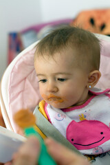 Primer plano de un bebé comiendo potitos