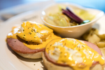 Weekend vegetarian breakfast in Scotland with two eggs benedict on homemade muffins with spinach and yellow hollandaise sauce.
