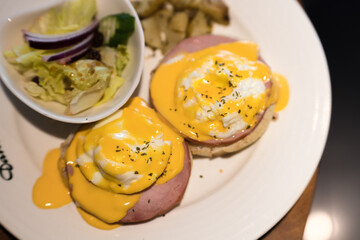 Weekend vegetarian breakfast in Scotland with two eggs benedict on homemade muffins with spinach and yellow hollandaise sauce.