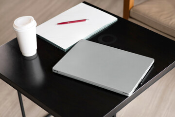 Workplace, laptop and notepad with pen and coffee on wooden table