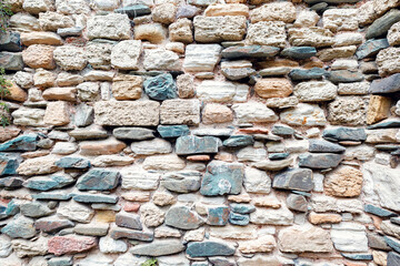 Stone tiles wall texture antique rock texture history construction archaeological exploration. Natural stone wall tiles texture. Old rock rustic textured stone pattern wallpaper surface.