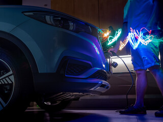 Closeup of an Asian  guy charging his EV car at home. Showing some electric wave going inside the car.