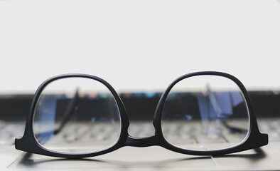 close up eyeglasses on a laptop computer with a display screen background.