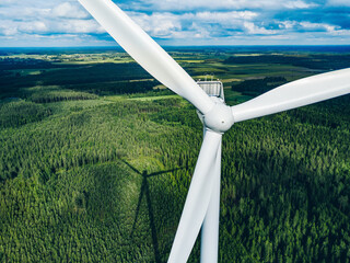 Aerial view of windmill close-up in green summer forest in Finland. Wind turbines for electric...