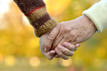 Boy and grandmother hands together over natural background