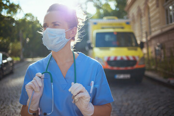 modern paramedic woman in uniform outside near ambulance