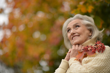 Beautiful senior woman posing outdoors in autumn