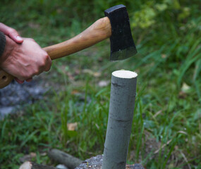 A man with an ax cuts a log. Technique at work.