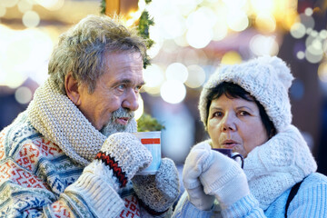 Seniorenpaar trinkt Glühwein auf dem Weihnachtsmarkt