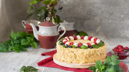 Napoleon cake with raspberries and cream on red napkin on grey wooden background. Selective focus