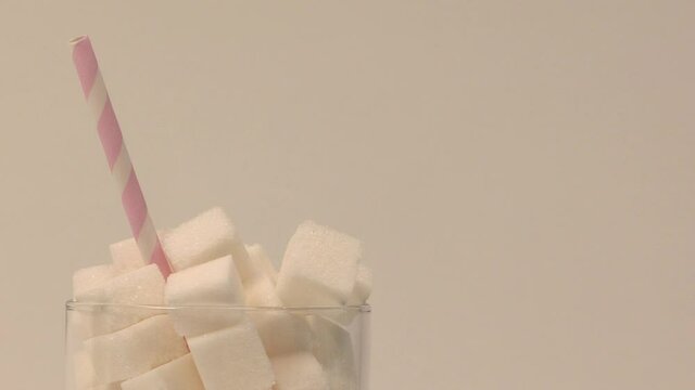 A glass full of sugar with a straw