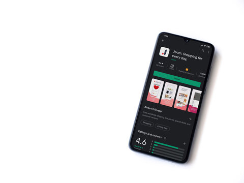 Lod, Israel - July 8, 2020: Joom app play store page on the display of a black mobile smartphone isolated on white background. Top view flat lay with copy space.
