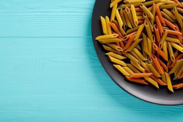 Raw pasta on a black plate, top view, copy space