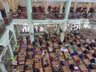 KUALA LUMPUR, MALAYSIA -AUGUST 14, 2020: The atmosphere in the mosque that practices social distancing while performing prayers during the Covid-19 pandemic. Muslim men are performing Friday prayers.