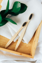 Fototapeta na wymiar Toothbrushes made of natural bamboo close-up close with green leaves