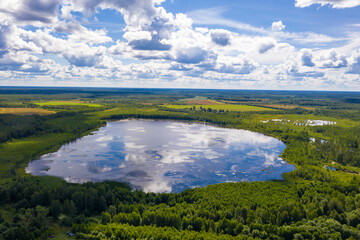 A small lake surrounded by green forest near the village of Bunkovo, Ivanovsky district, Ivanovo region, Russia.