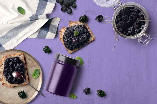 A breakfast scene with blueberry jam on bread. The purple tones with green highlights makes for a cheerful, vibrant background.