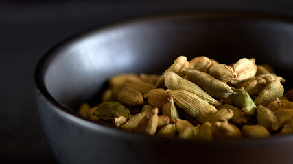 Cardamom on a black plate.