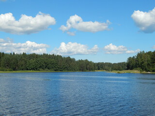 Landscape with blue sky, lake and white clouds