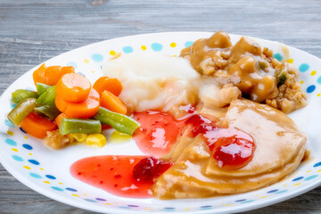Turkey dinner with potatoes and cranberry sauce served on a plate