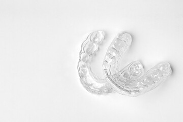 Invisible orthodontic removable braces on a white background with copy space. Aligners for straightening of teeth. 