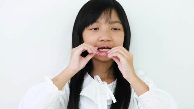 Asian child girls are wearing removable braces for children with orthodontic problems on white background