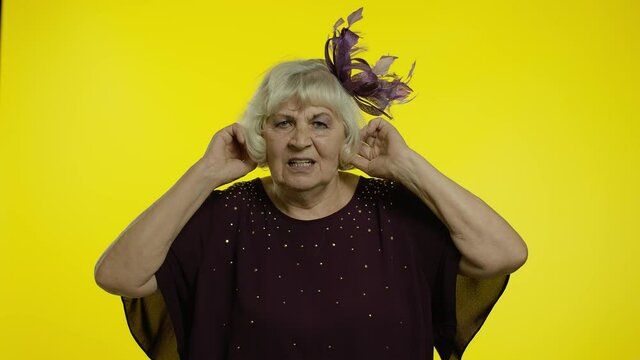 Annoyed irritated senior old woman covering ears and gesturing No, avoiding advice, ignoring noise