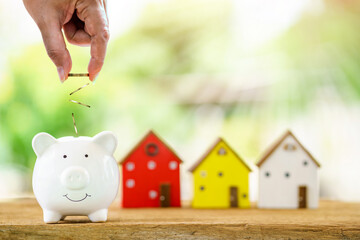 Piggy bank and drop gold coin on the top for saving money with growing a interest and wood home...