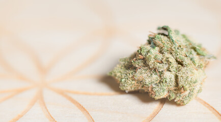 Premium marijuana macro shot on patterned wooden surface.  Room for copy on left.  Recreational or medical marijuana close up detail view.