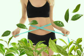 Young woman measuring her waist on light background, closeup. Tea leaves for slimming drink