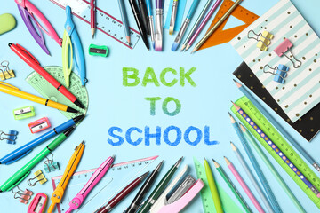 Text Back To School and different stationery on light blue background, flat lay