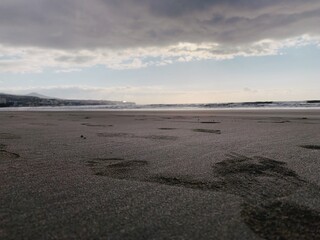 sunset over the beach with footprints