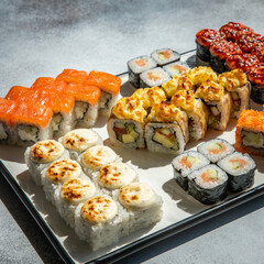 sushi set and sushi roll on wooden board