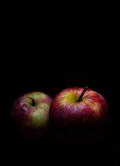 portrait of two isolated fresh apples on black background