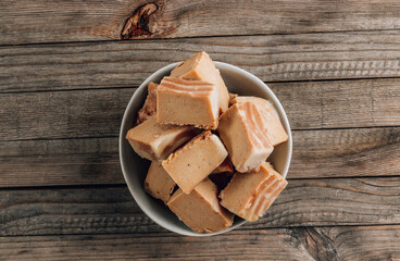 Raw vegan peanut butter fudge on a rustic wooden background.