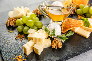 Different types of cheeses on black board.