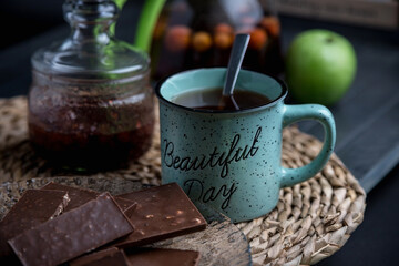 Turquoise mug with tea. Glass teapot with berry tea. Green apple. Still life on a dark table.