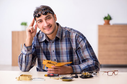 Young male watchmaker working in the workshop